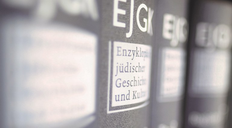 Four grey volumes in a book shelf